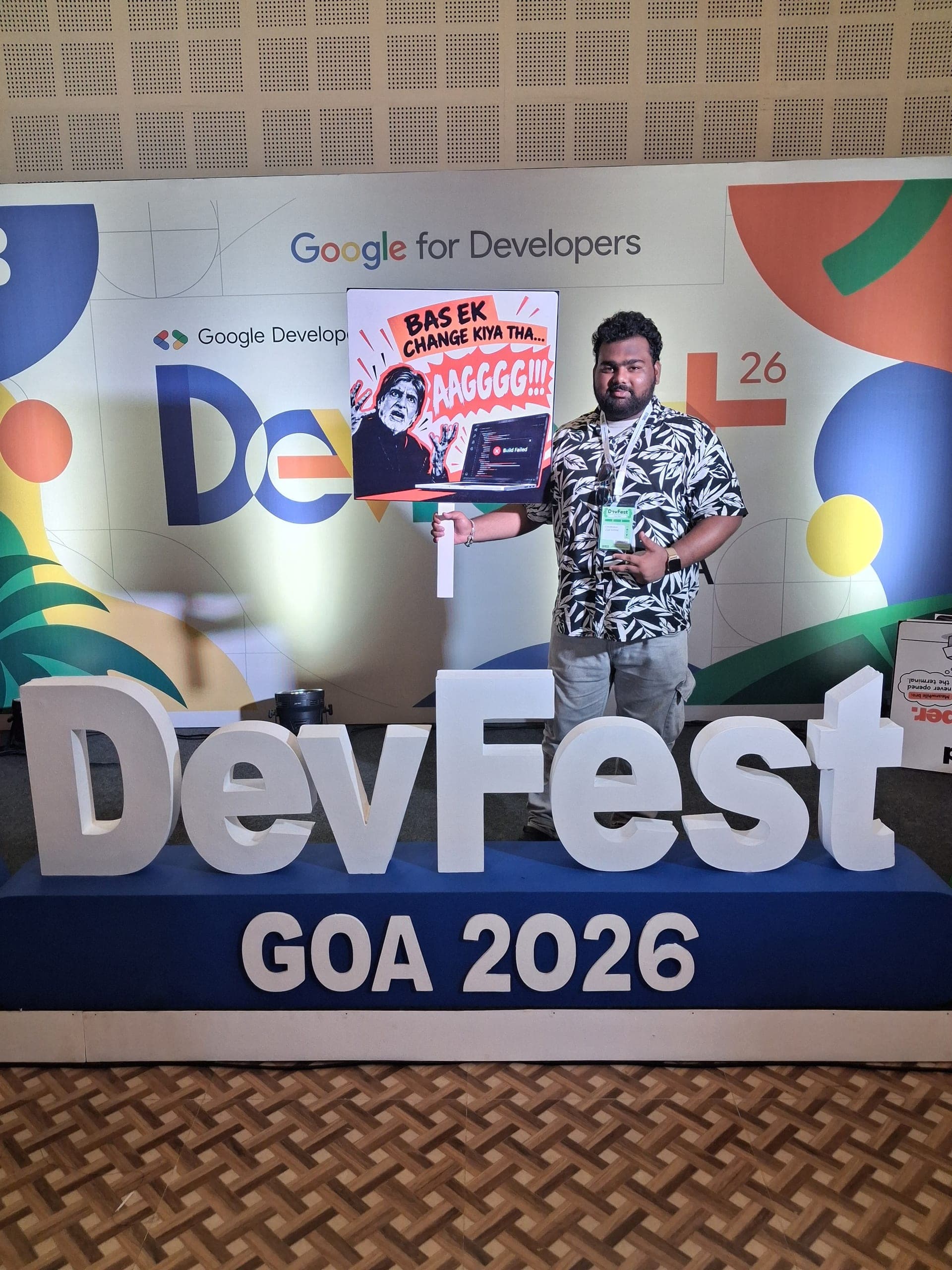 Shubham Chawhan holding a sign that reads “Bas Ek Change kiya tha… AAGGG!!!” at GDG DevFest Goa.